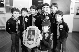 Young Timothy Hutton displays a Holme Valley cub scout swimming trophy watched by other Young Timothy Hutton displays a Holme Valley cub scout swimming trophy watched by other