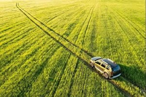 Russia Collection: Aerial view of Renault Duster car SUV driving on countryside road in spring field rural landscape