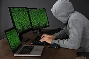 Binary Code Print of a Hacker Typing at a Desk