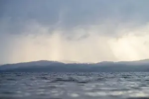 Clouds and sunlight print over water