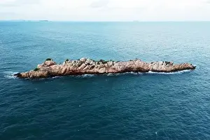 Drone Top View Print of Rocky Island Over Blue Sky