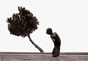 Woman in landscape bending body to imitate bending tree