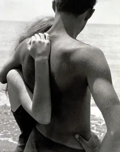 The First Love'. A young couple embracing, with their backs to the camera, on the seashore