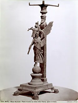 Table leg: on the base a Winged Victory on a Globe