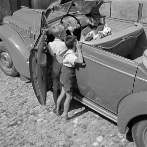 Austria, 1930s Print: Two boys and a fox terrier in an Opel Blitz