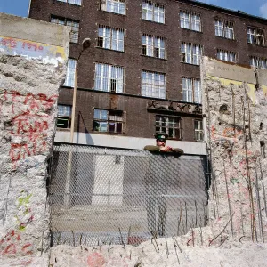 Berlin 1990 Print: A DDR-Grenzpolizist looks through the open Berlin Wall