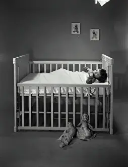 Prints of Boy sleeping in crib May Prints: Boy sleeping in crib Print