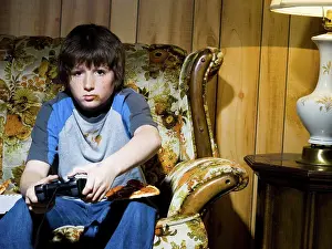 Prints of Boy with video game controller on sofa May Prints: Boy with Video Game Controller Print