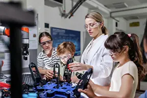 Prints of Children learning robotics in Elementary school. Young students programming, building robot in after school robotics club. Field trip to real robotics laboratory June Prints: Elementary School Robotics Print