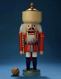 Christmas Celebration Decorations Prints: Close-up of a nutcracker with a walnut beside it
