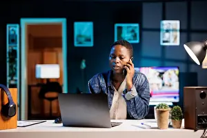 Multitasking Professional Prints: Multitasking professional efficiently manages a conversation on her mobile device while simultaneously working