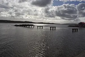 Deserted Waterfront Structures Prints: Abandoned and half-destroyed pier structures under a cloudy sky