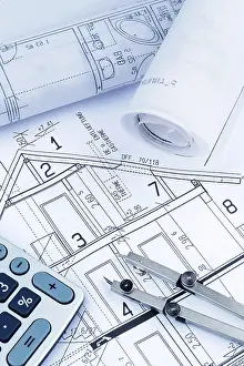 New House Financing Prints: An architect's construction plan with a calculator