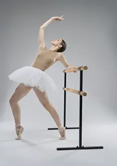 Female Ballet Dancer Pose Prints: A ballet dancer performs an elegant stretch at the barre
