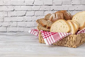 Food Photography Rustic Style Prints: A basket with different types of bread on a brick wall