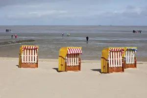 Low Tide Germany Prints: Beach chairs on sandy beach and back mudflat strollers