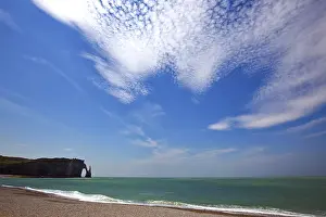 Coastal Area In France Prints: Beach with rocks under cloudy sky
