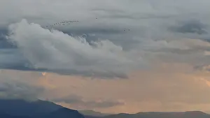 Cloudy Mountainous Landscape Prints: Birds against a dramatic sky with clouds and distant mountains