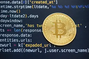 Virtual Money Transfer System Prints: A Bitcoin coin on top of computer programming code