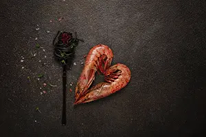 Prints of Black spaghetti, wrapped on a fork, langoustines in the shape of a heart, on the table, dish concept, dish background, top view Langoustine Prints: Black Spaghetti Print with Langoustines