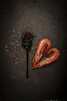 Prints of Black spaghetti, wrapped on a fork, langoustines in the shape of a heart, on the table, dish concept, dish background, top view Langoustine Prints: Black Spaghetti Print with Langoustines