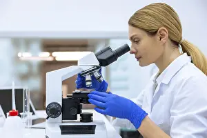 Medical Care Specialist Prints: Blonde scientist working with microscope