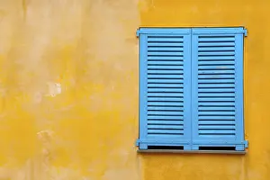 Deserted House Window Prints: Blue shutter on yellow plaster wall