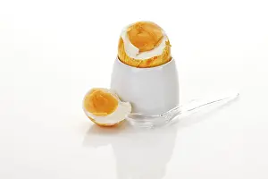 Coloured Easter Eggs Prints: Boiled breakfast easter egg in an egg cup with egg spoon