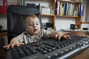 Young Boy At Desk Prints: Boy, 10 months, using a pc keyboard