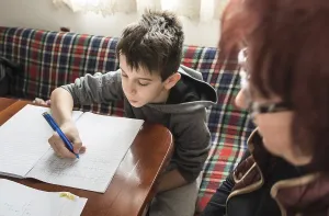 Young Boy Studying Prints: Boy do his homework. Notebook