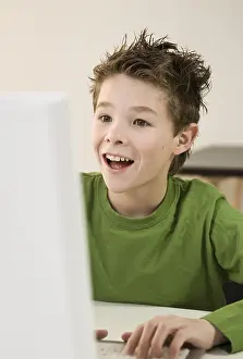 Young Boy Smile Prints: Boy laughing, sitting in front of his computer