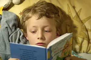 Boy Reading In Bed Prints: Boy reading in bed