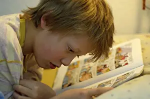 Relaxing With A Book Prints: Boy reading in bed