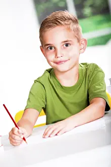 Caucasian Boy Smiling Prints: Boy with a sketch-pad at a table