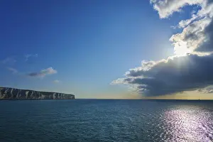 Steep Cliff Coastal Area Prints: Brilliant sunlight through clouds over ocean and cliffs