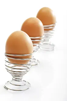 Studio Shot Of Brown Eggs Prints: Brown eggs in wire egg cups
