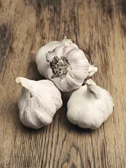 Healthy Eating Concept Image Prints: Four bulbs of garlic on a rustic kitchen table