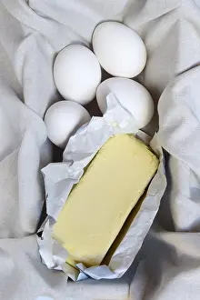 Plain Background Food Photos Prints: Butter in opened packaging and eggs