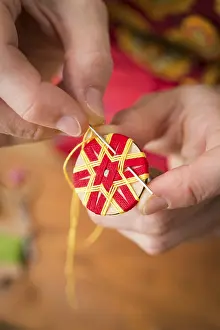 Traditional Bavarian Crafts Prints: Button maker stitching and wrapping red and yellow yarn into star pattern
