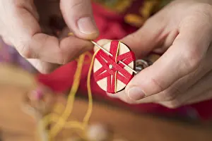Traditional Crafts Germany Prints: Button maker stitching and wrapping red and yellow yarn into star pattern