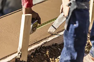 Construction Site Laborer Prints: Cement construction worker using measuring tape while forming pool coping