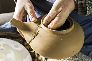 Handcrafted Goods Europe Prints: Ceramic workshop, hands checking fit of spout on pot