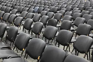 Empty Chair Rows Prints: Chairs covered with gray plastic stand in rows in a function room