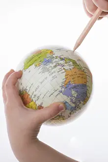 White Background Photography Prints: Child holding a globe and a pen in on a white background