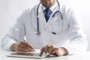 Doctor Examination Prints: Close up of male doctor hands using tablet computer