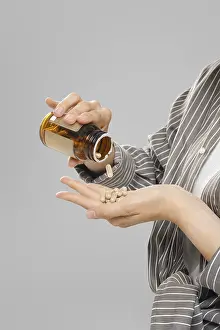 Medical Care And Wellbeing Prints: Close up view of pill falling out of a jar