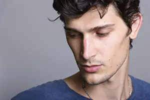 Close Up Portrait Prints: Close up of young handsome man thinking while looking down