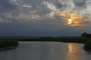 Water Reflection Germany Prints: Cloudy sky at sunset over a river with slight reflection