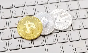 Digital Currency Symbol Prints: Coins of cryptocurrency lying over computer keyboard