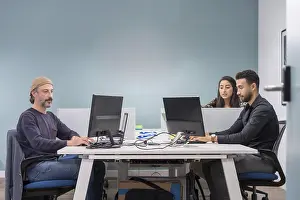 Young Professionals At Work Prints: Colleagues in a co-working office working while using computers